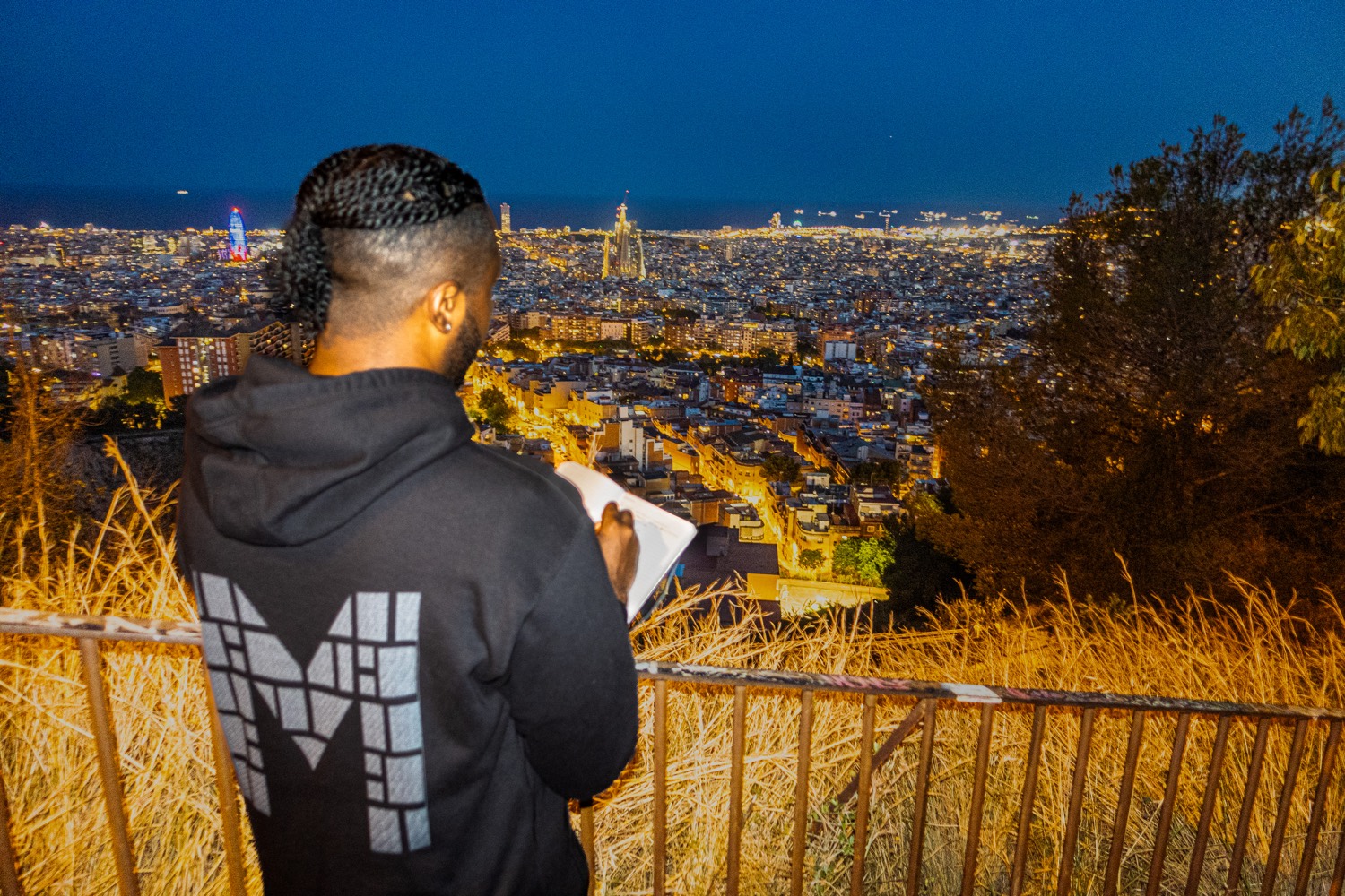 Writing in a notebook above the Barcelona grid, Sagrada Família on the horizon